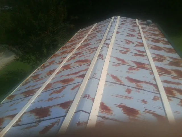 Rusted metal roof panels with new wood purlins before replacement — Storm Damage Roof Repair in West End by Roofing Brothers